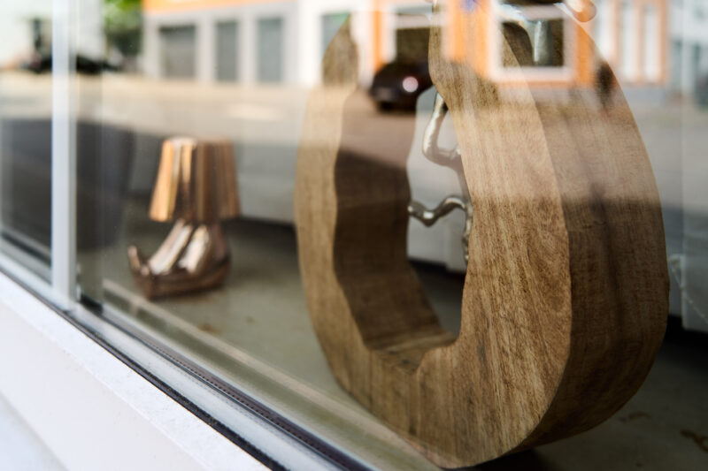 Eine Nahaufnahme der Dekoration in meinem Schaufenster, mit einer Holzskulptur und einer niedlichen kleinen Lampe.